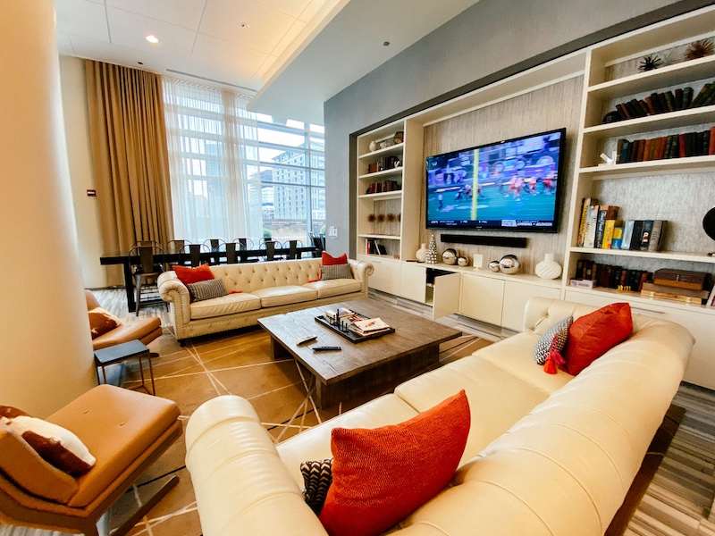 The resident lounge at Chicago's K2 Luxury Apartments, located in the Fulton River District. The resident room has ample seating, cozy decor, a coffee table, and a large TV.