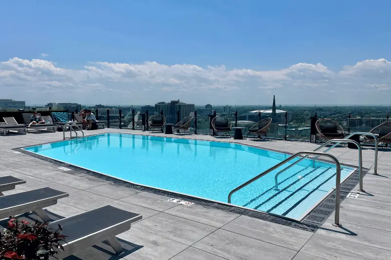 The outdoor, rooftop pool at Parq Fulton apartments, with views of the sprawling West Loop neighborhood below a blue sky.